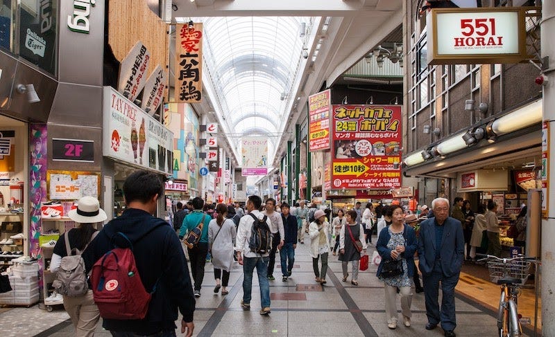 People walk through one of Osaka’s many shotengai shopping arcades