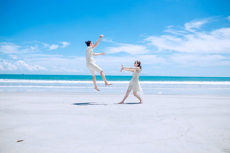 woman and man modern dancing on the beach