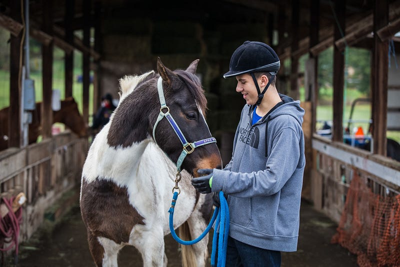 Forrest and Obi share a moment while waiting for the horse trainer. Forrest worked with Obi for a day camp last summer, as well as when he volunteered as a mentor at ANT. He now volunteers to help train another horse, but still visits Obi whenever he has a chance.