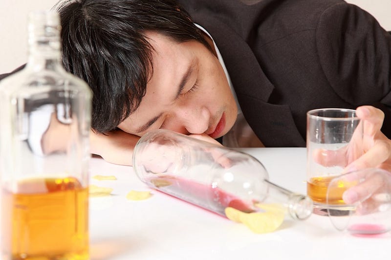 A salaryman passes out after drinking too much in Japan with his co-workers