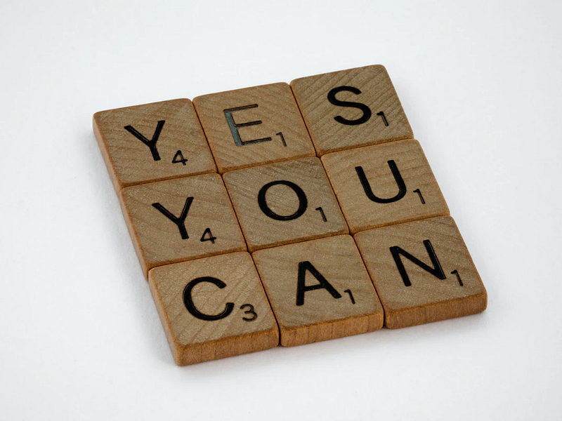 scrabble letters arranged to show the words "yes you can"