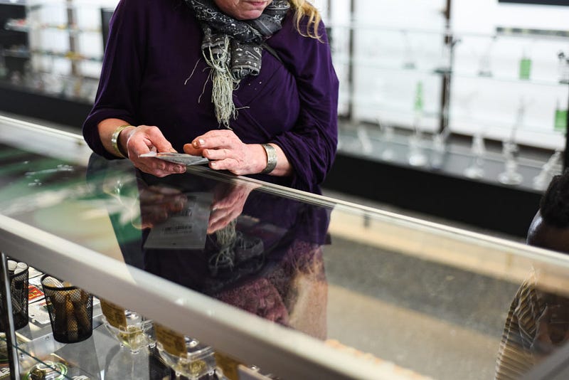 Karen Brusher browses through various cannabis products at the Joint in Bellingham, while reading the product details listed on the label.