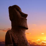 A stone statue on Easter island at sunset