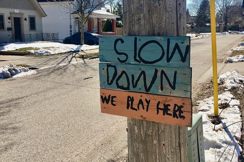 sign posted by neighbourhood kids saying slow down we play here