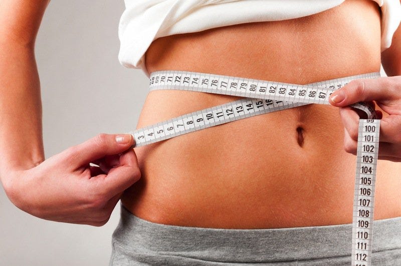 woman measuring flat abs