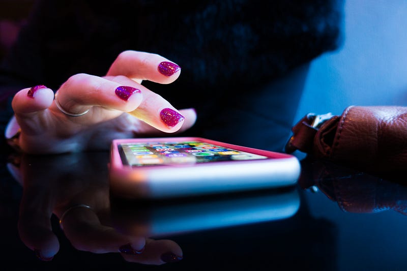 A girl with manicured nails tapping a phone screen