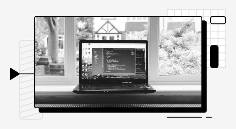 A computer with an open IDE in front of a window.