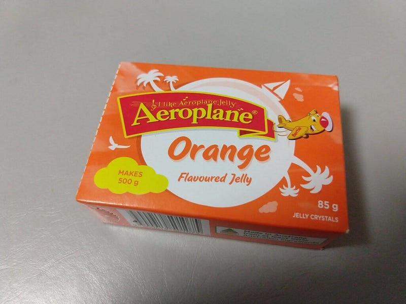 An 85 gram package of orange-flavoured Aeroplane Jelly.