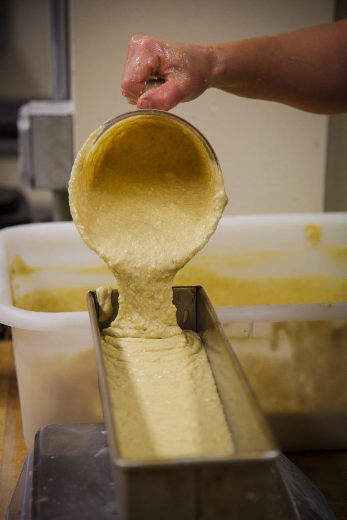 Williams pours her whole grain cornbread mix into pans before baking them. 