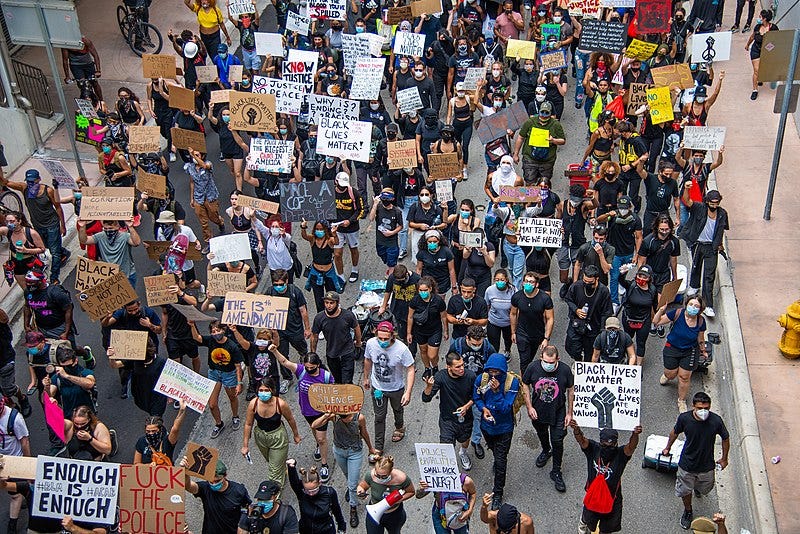 Bird’s eye view of Black Lives Matter protesters marching along a street.