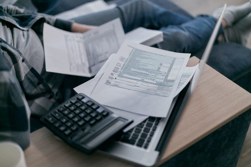 a laptop and calculator with papers on top