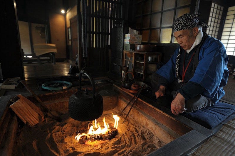 A man sits in front of an irori hearth at Tokyo’s historic Edo-Tokyo Open Air Architectural Museum