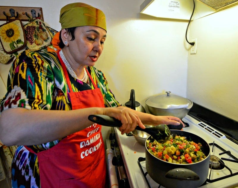 League of Kitchens instructor cooking a meal on the stove