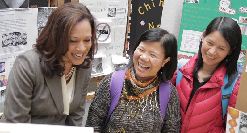 Students Dantong Zhang Sin and Qingmian Xue share a laugh with Calif. Atty Gen. Kamala Harris as she looks at their Chinese Family Reunion and Renewal of Family Bonds project in the Laney Library Oct. 11.