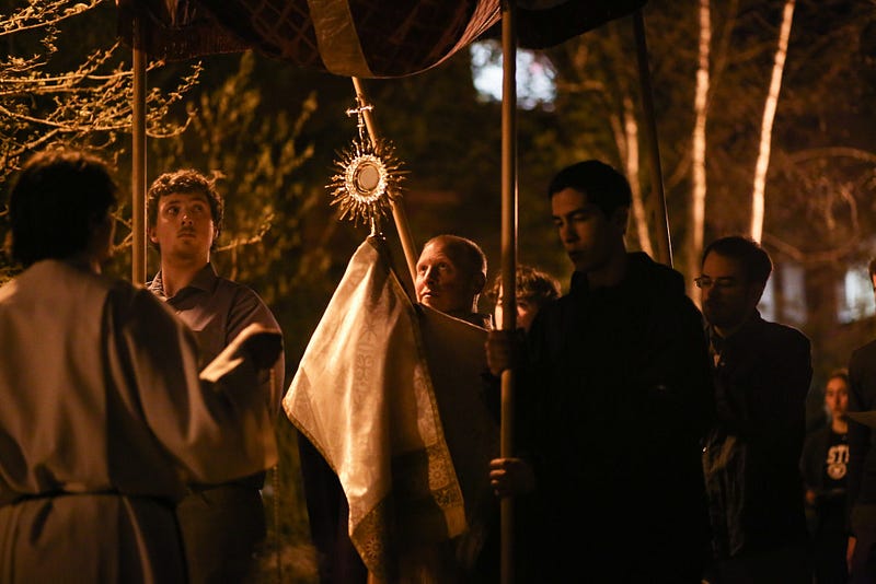 After leading a mass on campus, Altenhofen proceeds with a group of students and parishioners down to the Newman center singing hymns and swinging incense.