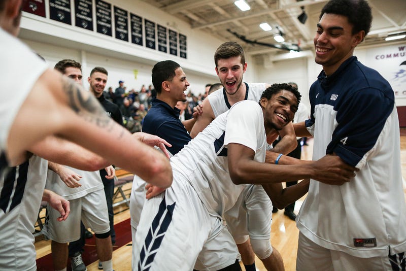 Finally, a smile appears on Jeff’s face as he is pushed back and forth by his teammates upon his entrance to the court.