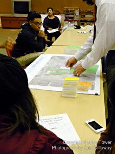 A representative architect from Hibser Yamauchi Architects, Inc., lays “purpose” blocks on a map of the OUSD property where Dewey high school currently sits. This process helps explain to the participants the constraints the community faces in trying to achieve the best possible outcome for this contentious development.