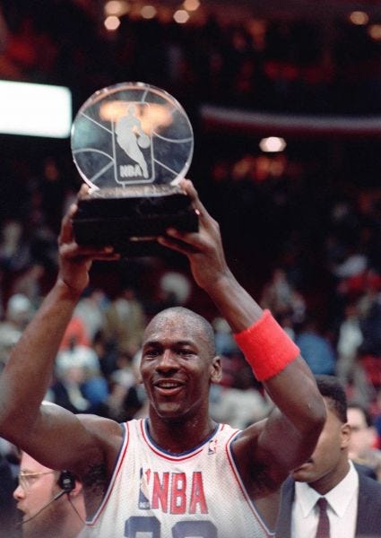 Michael Jordan holds his All-Star Game MVP trophy in 1988.