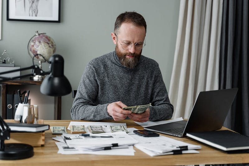A man counting cash for budgeting at office