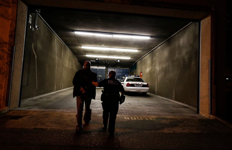 Bellingham Police Officer Andria Fountain walks a man into the Whatcom County Jail to be processed and admitted for the night. The man, arrested for driving under the influence, claimed to only have one beer that night but registered a blood alcohol content level .09 above the legal limit. Fountain, who was the first of four officers on the scene, says that many people don't realize how fast officers have to make life-impacting decisions in the field, which is one of the reasons body cameras are being implemented. Nick Danielson / Klipsun Magazine