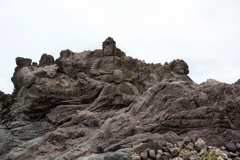 Some arhat statues (disciples of Buddha) carved into the rock part of Juroku Rakan Iwa or the 16 Buddha along the coast at the base of Chokai-san.