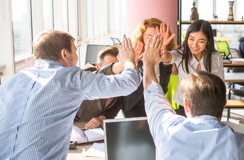 A company team all high fiving each other