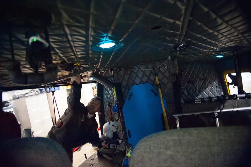 Crew Chief, Deputy Beau Beckner, secures equipment inside of the UH-1H helicopter named SnoHawk 10 in preparation for the days helicopter rescue training. The crew typically does a practice run through in the hanger before flying out to a predetermined location for training to make sure that everything is ready and that everyone is following proper procedure.