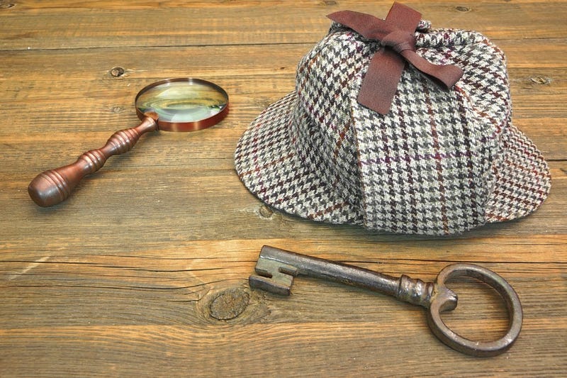 Sherlock Holmes Cap famous as Deerstalker, Old Key and Retro Magnifier on Grunge Wooden Table