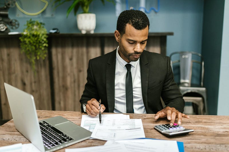 employee using a time card calculator and writing down on paper