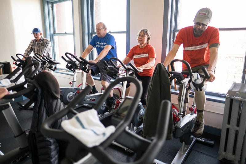 Rick Hermann pedals at the YMCA in a spin class that helps him combat the symptoms of Parkinson’s disease. During the hour-long bike ride, the participants exchange stories about their lives and talk while they ride for an hour.