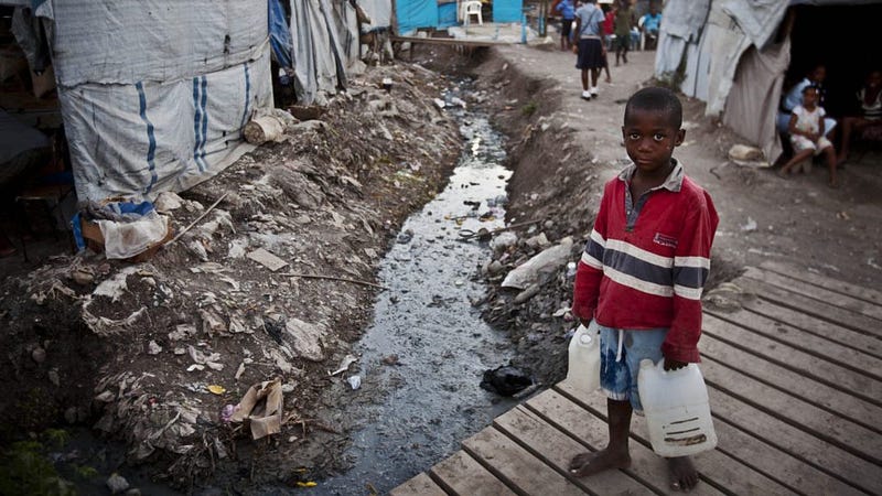 A Haitian boy carries water taken from a stream. (Care.org)