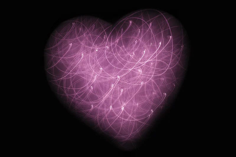 A purple heart made of swirling bright lights against a black background