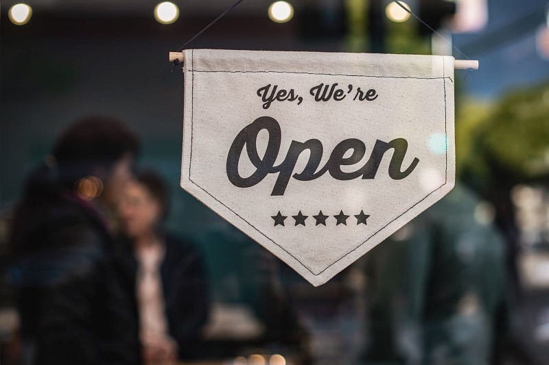 A "yes, we're open" sign of a small business