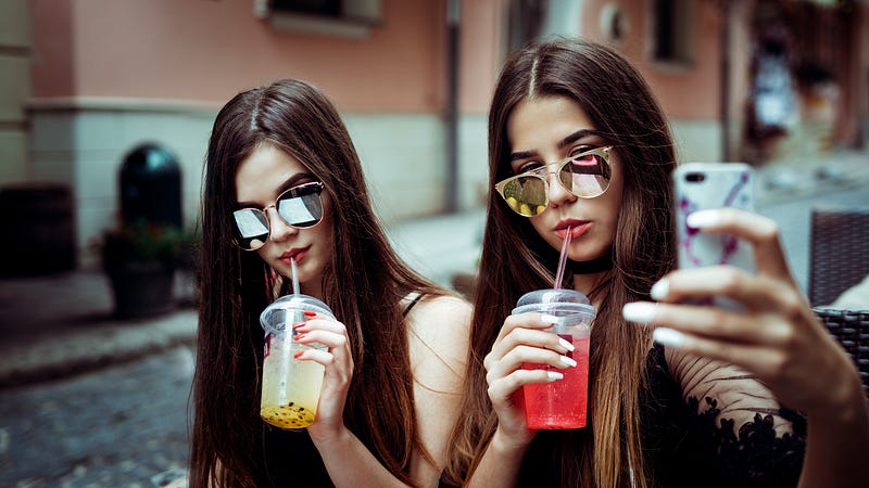 Two social media influencers taking a photo of themselves.