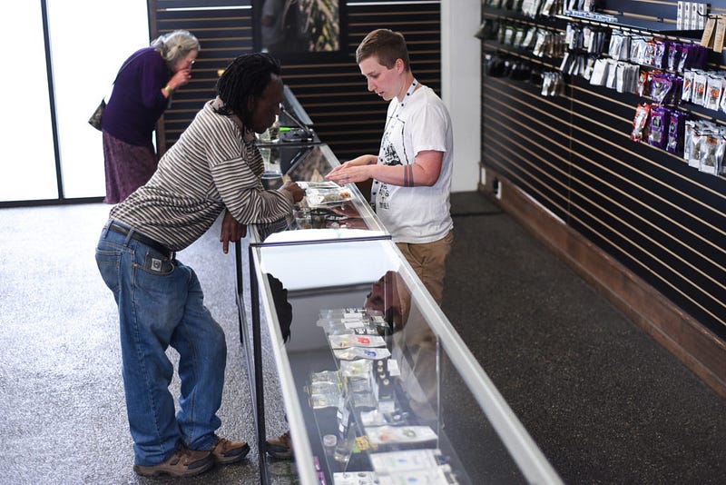 :Dumi Hlangqane and Karen Brusher spend time learning about the different strains sold at The Joint, located on James Street in Bellingham, Washington.