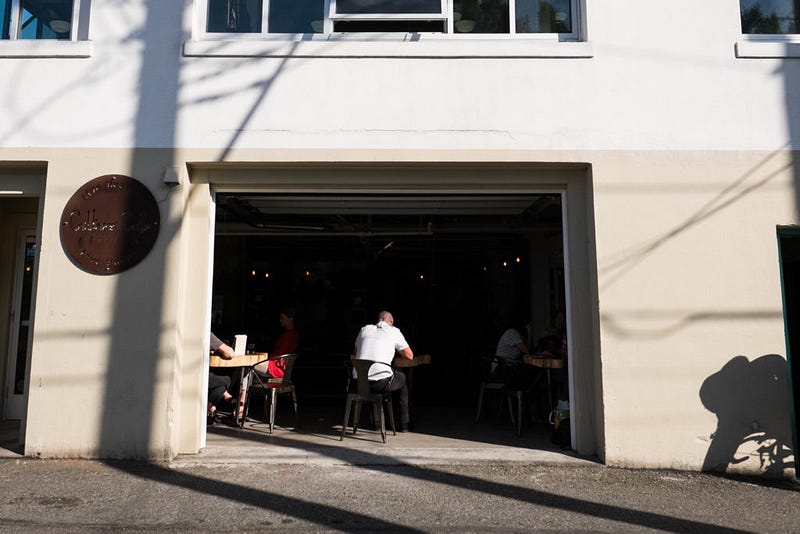 Afternoon sunshine illuminates customers at the Culture Cafe at Kombucha Town. The cafe serves their kombucha brewed in the back of the building while also serving beer on tap and cocktails as well as a food.