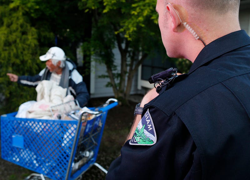 Bellingham Police Officer Keith Johnston, one of the department's officers who wears a body camera, talks with a homeless man who is frequently reported for welfare checks. The reported man was sleeping outside of the Northwest Chiropractic Clinic on April 25, 2015. As long as they are already turned on, the body cameras that are being used retrieve the past 30 seconds of video once they start recording, which allows officers to capture unpredicted events. Nick Danielson / Klipsun Magazine