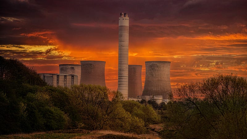 Power plant stacks in front of orange clouds