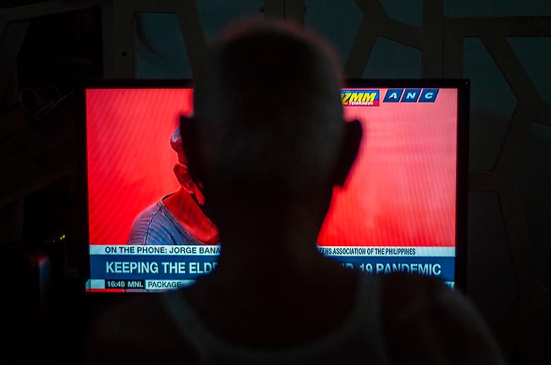 Silhouette of someone watching news on tv