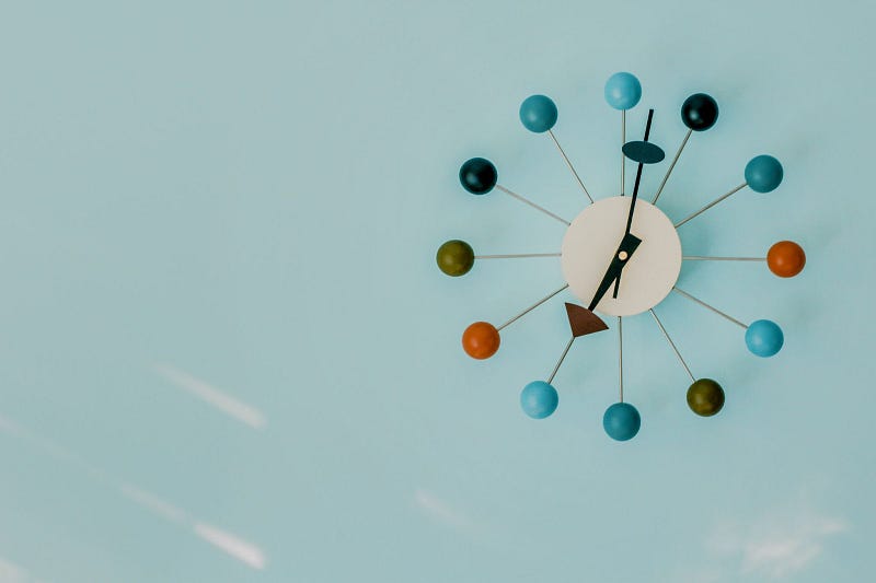 a contemporary clock set at 7:02 with a powder blue background