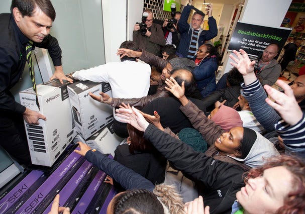 Shoppers jostle for electrical goods at a store in London, Friday Nov. 28, 2014. Americans celebrating Thanksgiving in Britain may have felt right at home as Black Friday shopping chaos caused some disruption. The practice of offering bargain basement prices the day after Thanksgiving has spread across the Atlantic, with some retailers opening overnight to lure determined shoppers. (AP Photo/PA, David Parry) UNITED KINGDOM OUT NO SALES NO ARCHIVE