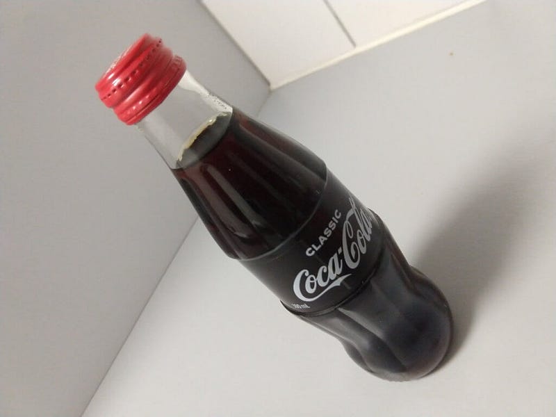 A 300ml glass bottle of Coca-Cola in the classic shape.