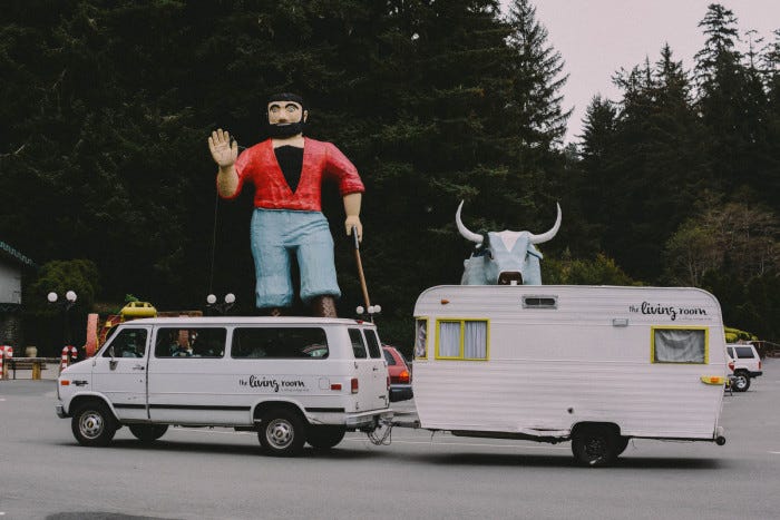 Ashley Hogrebe's camper parked in front of statues of Paul Bunyan and Babe the Blue Ox at the Trees of Mystery roadside attraction in California.
