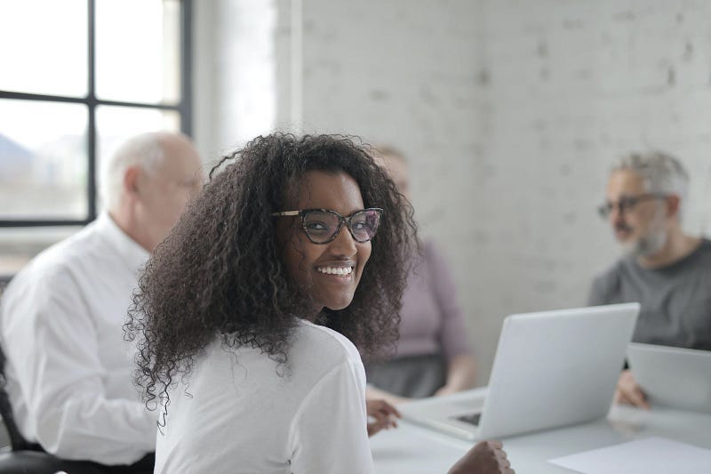 woman smiling at the camera with her team in the background