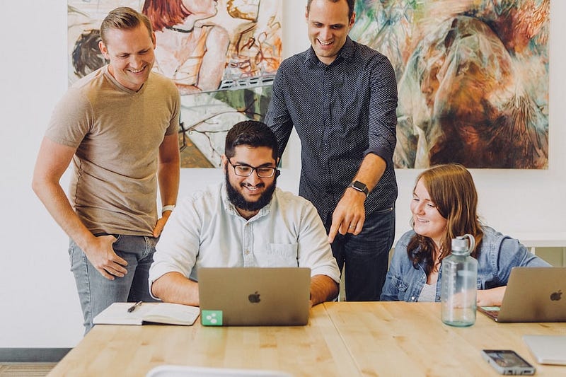 Happy colleagues looking at computer