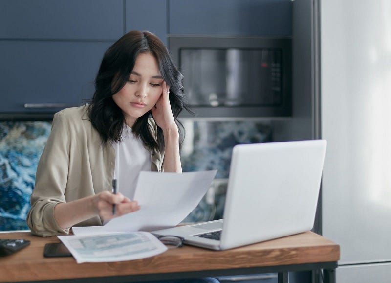 woman reading a paper in front of a laptop | procure-to-pay