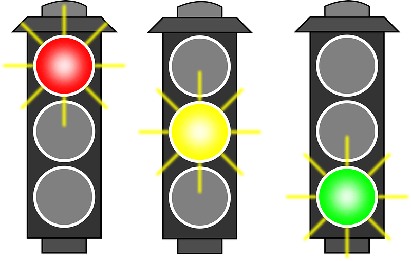 A picture of traffic lights in red, orange and green colours