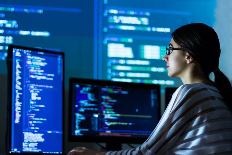 A girl reading codes on a computer screen