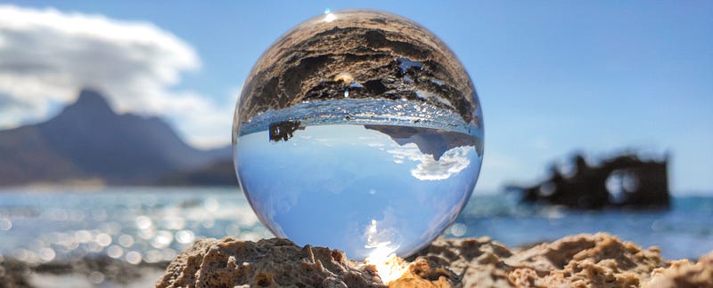 Crystal ball showing sky, water, and land upside down