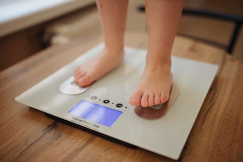 A child checking her weight